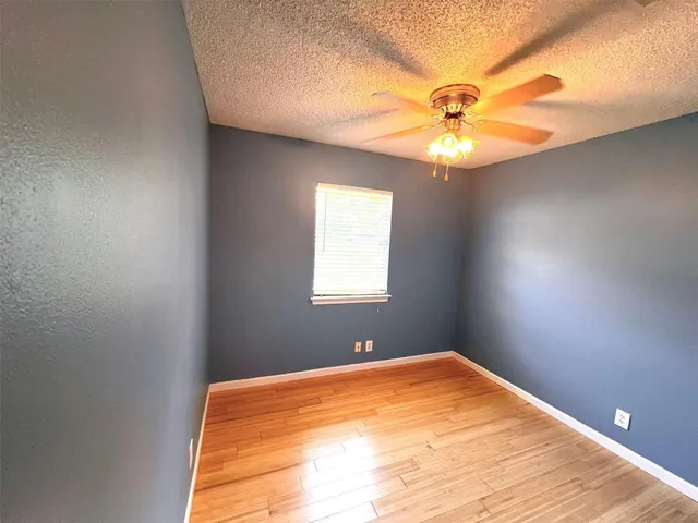 a view of a big room with window and chandelier fan