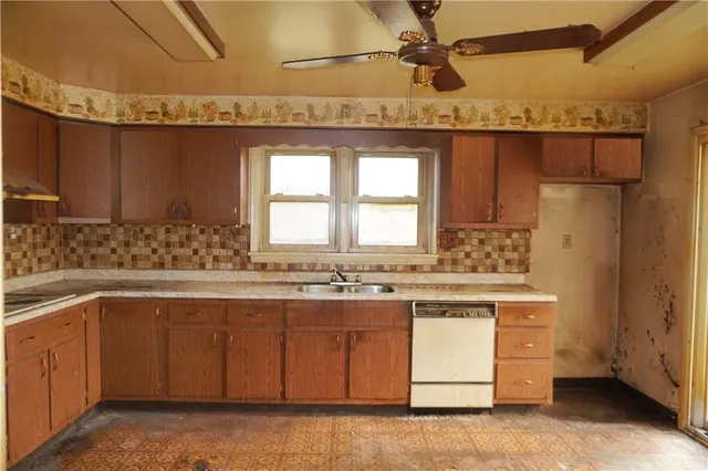 a kitchen with a sink a stove cabinets and a window