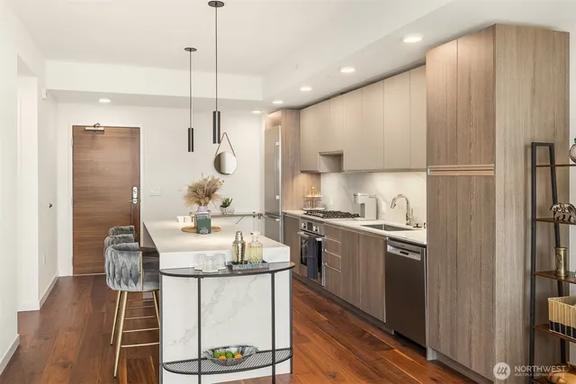 a kitchen with stainless steel appliances a dining table chairs stove and cabinets