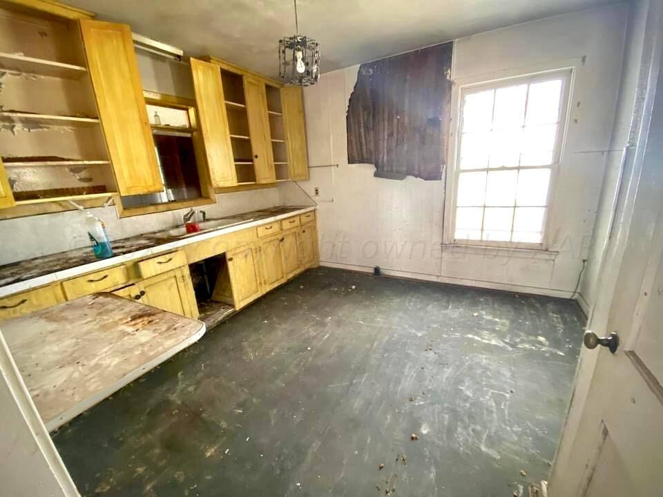 1303 Boyd Street Borger, TX 79007 - Photo 3 of 9 a view of a kitchen with a sink and dishwasher with wooden floor