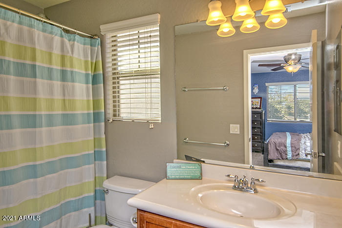 1941 West Davis Road Phoenix, AZ 85023 - Photo 15 of 24 a bathroom with a sink a toilet a large mirror and shower curtain
