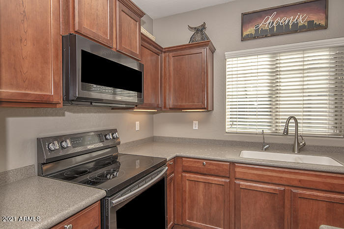 1941 West Davis Road Phoenix, AZ 85023 - Photo 6 of 24 a kitchen with stainless steel appliances a sink a stove cabinets and a microwave oven