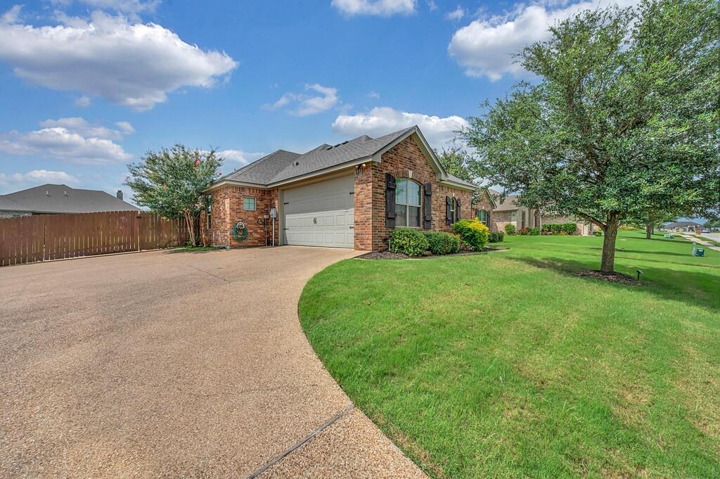 550 Hunton Lane Robinson, TX 76706 - Photo 33 of 35 View of front facade featuring a garage, driveway, brick siding, and a shingled roof