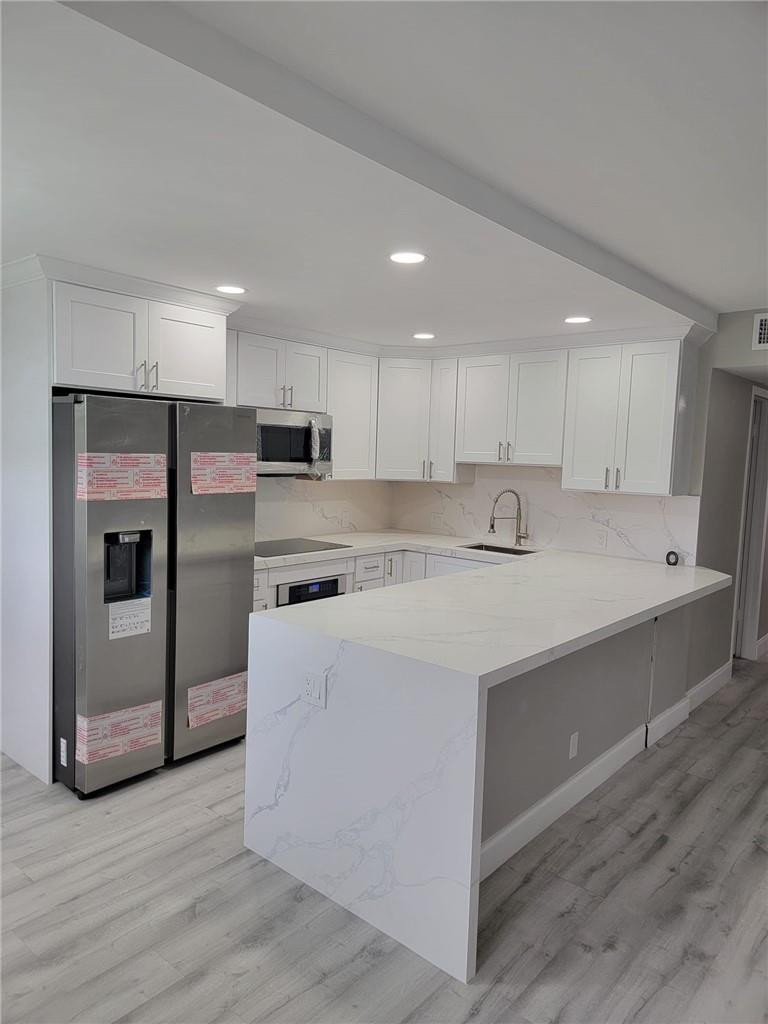 296 Brighton H, Unit H Boca Raton, FL 33434 - Photo 1 of 11 a kitchen with kitchen island a sink and a refrigerator