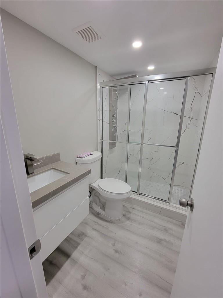 296 Brighton H, Unit H Boca Raton, FL 33434 - Photo 6 of 11 a bathroom with a sink a toilet and shower