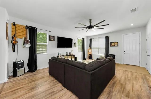 a living room with stainless steel appliances kitchen island granite countertop furniture a rug a stove and a sink