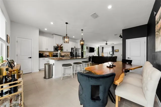 a kitchen with a sink a counter and a living room view