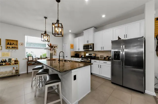 a kitchen with stainless steel appliances granite countertop a sink a stove and a wooden floors