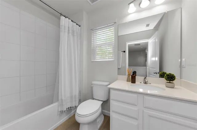 a living room with couches chandelier and a window with wooden floor