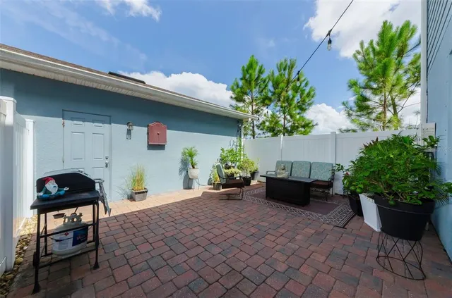 a view of a house with brick walls and a yard with plants