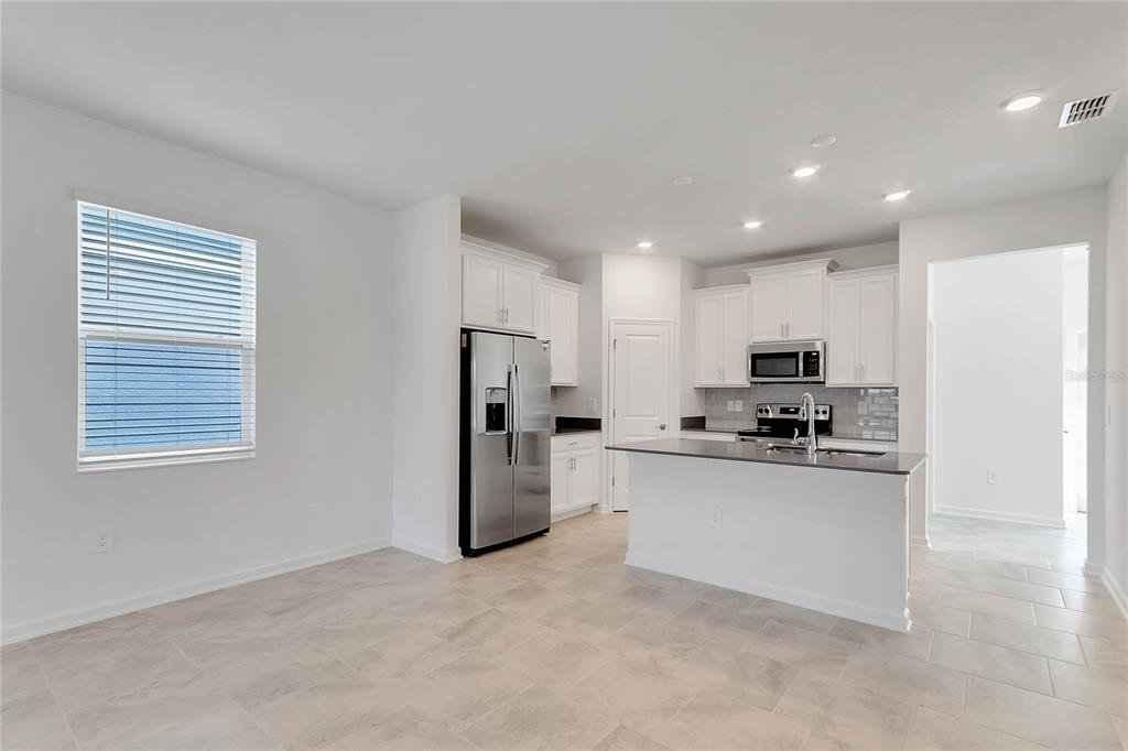 1721 Good Neighbor Loop Kissimmee, FL 34744 - Photo 5 of 28 a kitchen with stainless steel appliances a refrigerator a stove a sink a microwave and cabinets
