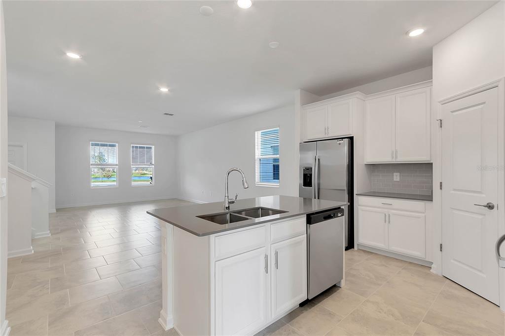1721 Good Neighbor Loop Kissimmee, FL 34744 - Photo 8 of 28 a kitchen that has a sink cabinets and refrigerator