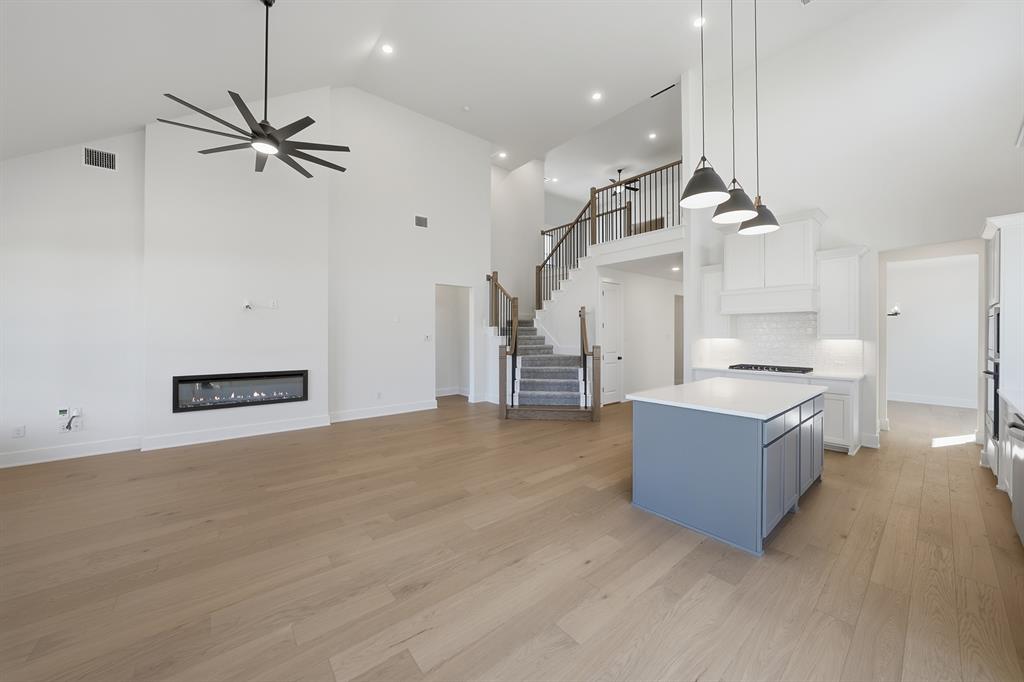 6028 Foxwheel Way Fort Worth, TX 76123 - Photo 36 of 37 Kitchen featuring blue cabinetry, open floor plan, hanging light fixtures, a center island, and white cabinets