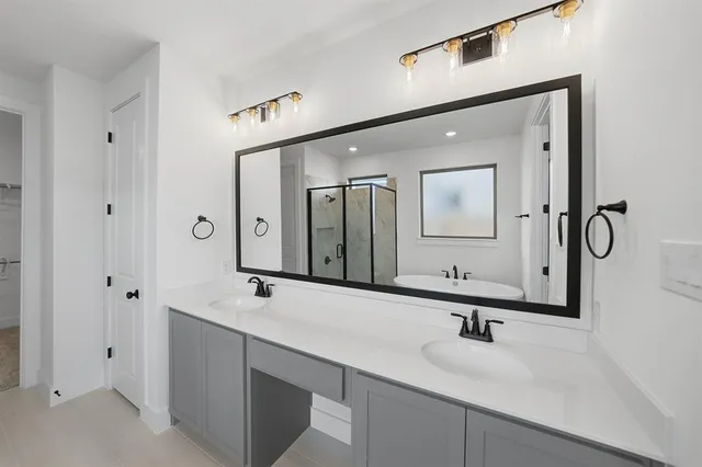 a bathroom with a double vanity sink mirror and