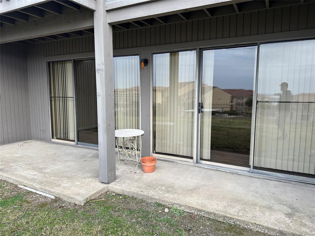 927 Signal Ridge Place Rockwall, TX 75032 - Photo 11 of 16 Concrete patio with multiple sliding glass doors and an exterior light fixture