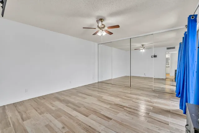 a view of empty room with wooden floor