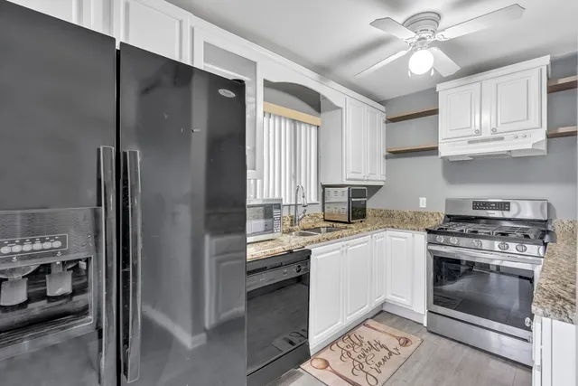 a kitchen with stainless steel appliances granite countertop a stove a refrigerator and a sink
