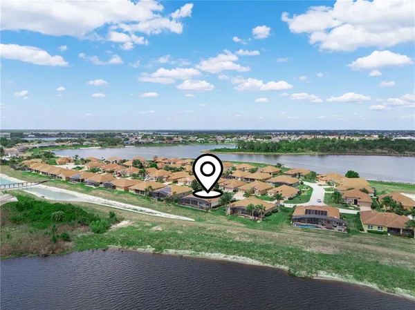 an aerial view of residential houses with outdoor space and lake view