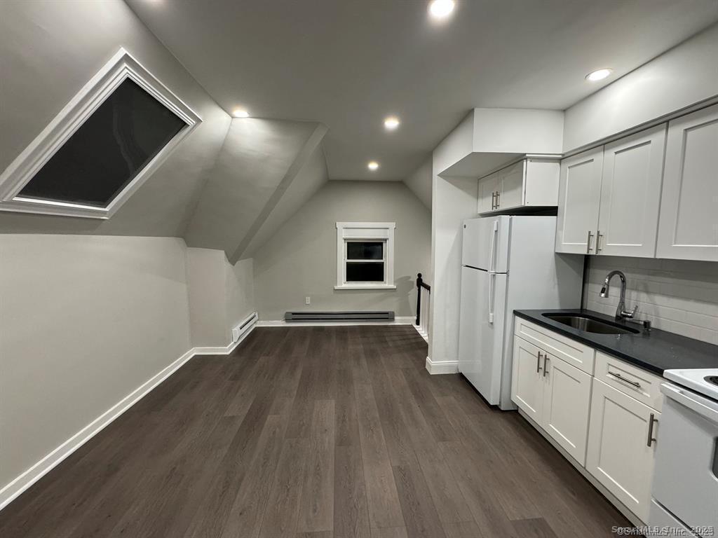 a kitchen with a refrigerator and white cabinets