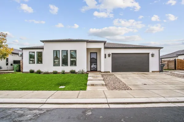 a front view of a house with a garden and yard
