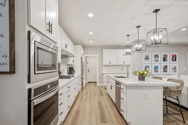 a kitchen with stainless steel appliances lots of counter space and wooden floor