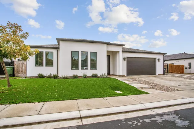 a front view of a house with a garden and yard