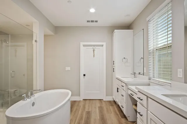 a bathroom with a granite countertop sink a mirror and a bathtub