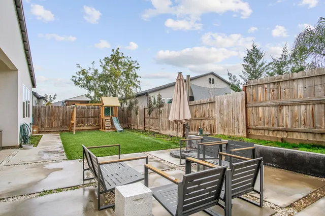 a view of a house with backyard and sitting area