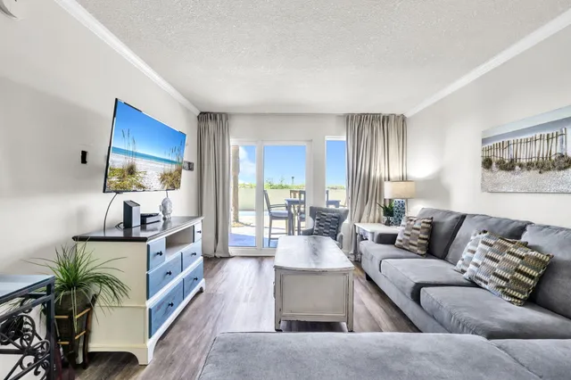 a living room with furniture wooden floor and a large window