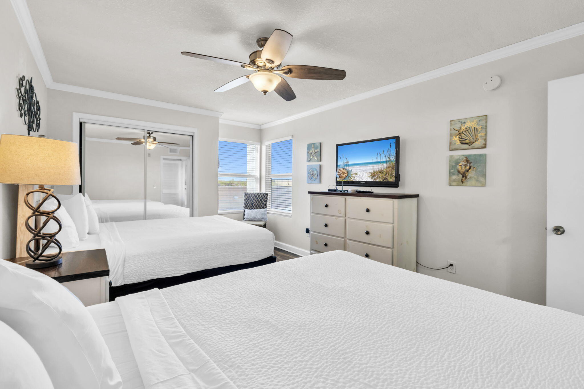 676 Santa Rosa Boulevard, Unit 1F Fort Walton Beach, FL 32548 - Photo 24 of 36 a bedroom with a bed a chandelier and a flat tv screen