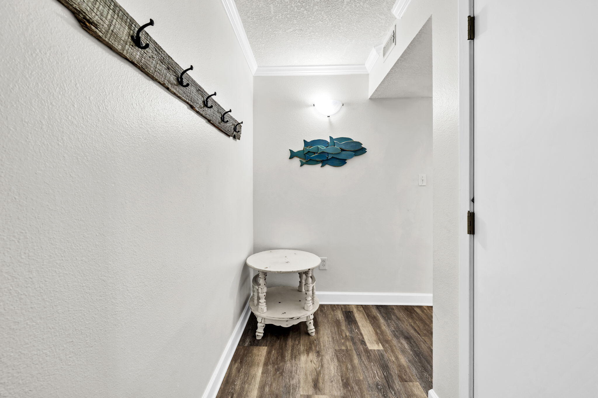 676 Santa Rosa Boulevard, Unit 1F Fort Walton Beach, FL 32548 - Photo 3 of 36 a view of a hallway with wooden floor and staircase