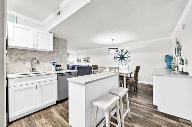 a kitchen with a dining table chairs and white cabinets