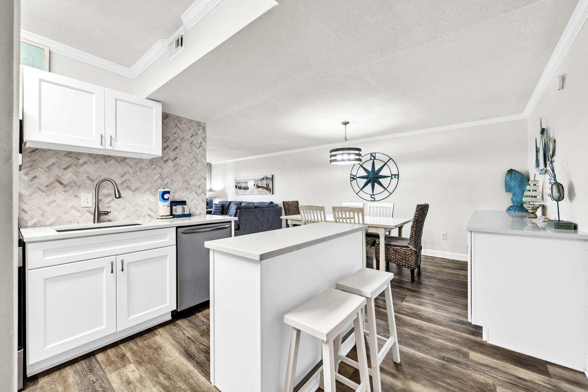 676 Santa Rosa Boulevard, Unit 1F Fort Walton Beach, FL 32548 - Photo 4 of 36 a kitchen with a dining table chairs and white cabinets