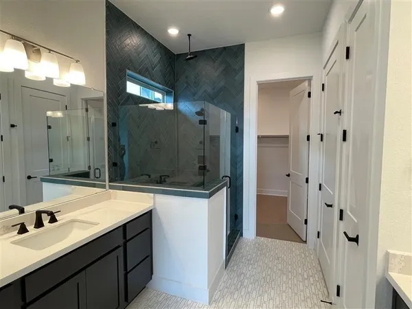 a bathroom with a double vanity sink mirror and shower