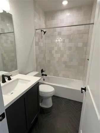 a bathroom with a bathtub shower sink vanity and toilet