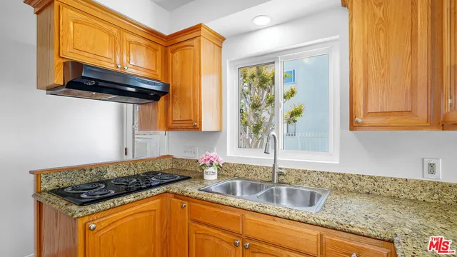 a kitchen with stainless steel appliances granite countertop a sink stove and cabinets