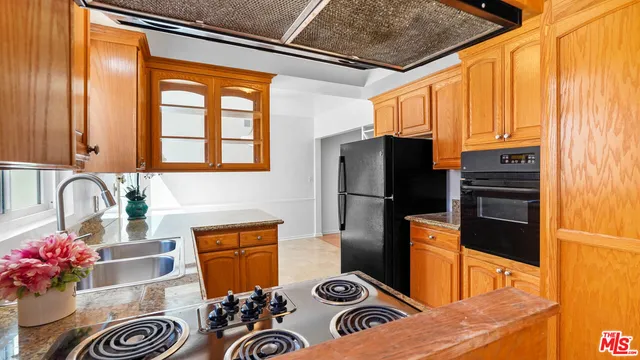 a kitchen with stainless steel appliances granite countertop a refrigerator and a stove