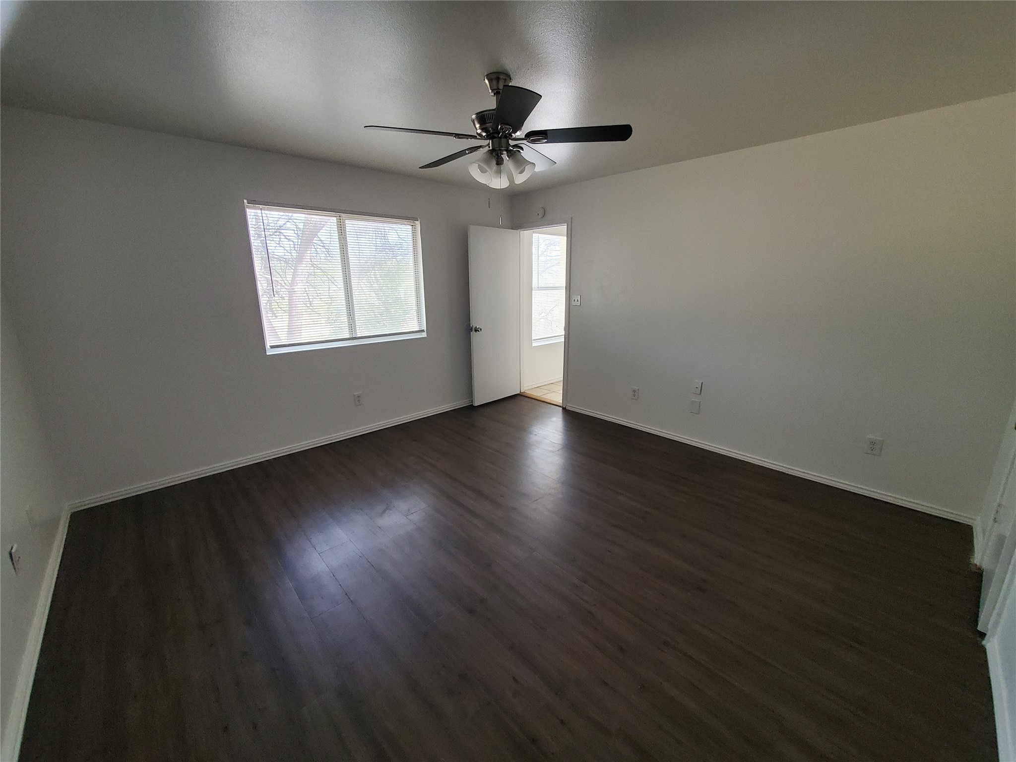 7209 Ritchie Drive Austin, TX 78724 - Photo 16 of 33 an empty room with wooden floor chandelier fan and windows