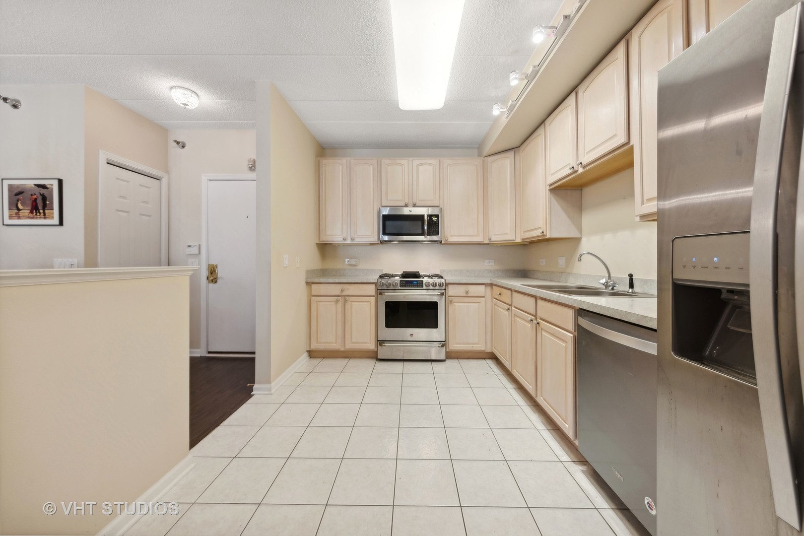 111 North Wheaton Avenue, Unit 306 Wheaton, IL 60187 - Photo 8 of 16 a kitchen with a sink a stove top oven and cabinets