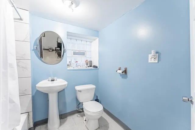 a bathroom with a toilet sink and mirror