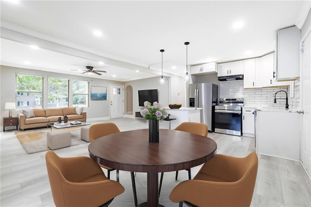 a dining room with furniture a large window and kitchen view