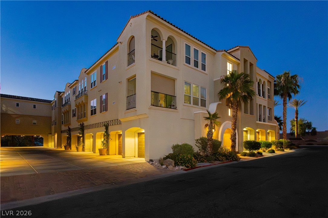 2555 Hampton Road, Unit 3308 Henderson, NV 89052 - Photo 41 of 65 Illuminated archways and balconies adorn this inviting multi-story residence with vibrant landscaping.