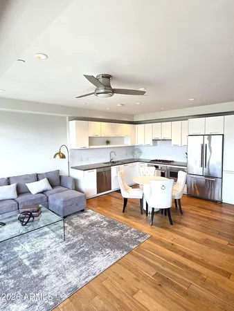 a living room with furniture and a wooden floor