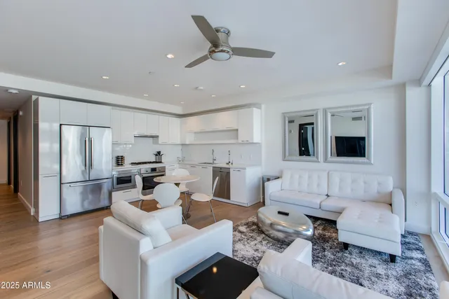 a living room with furniture white walls and kitchen view