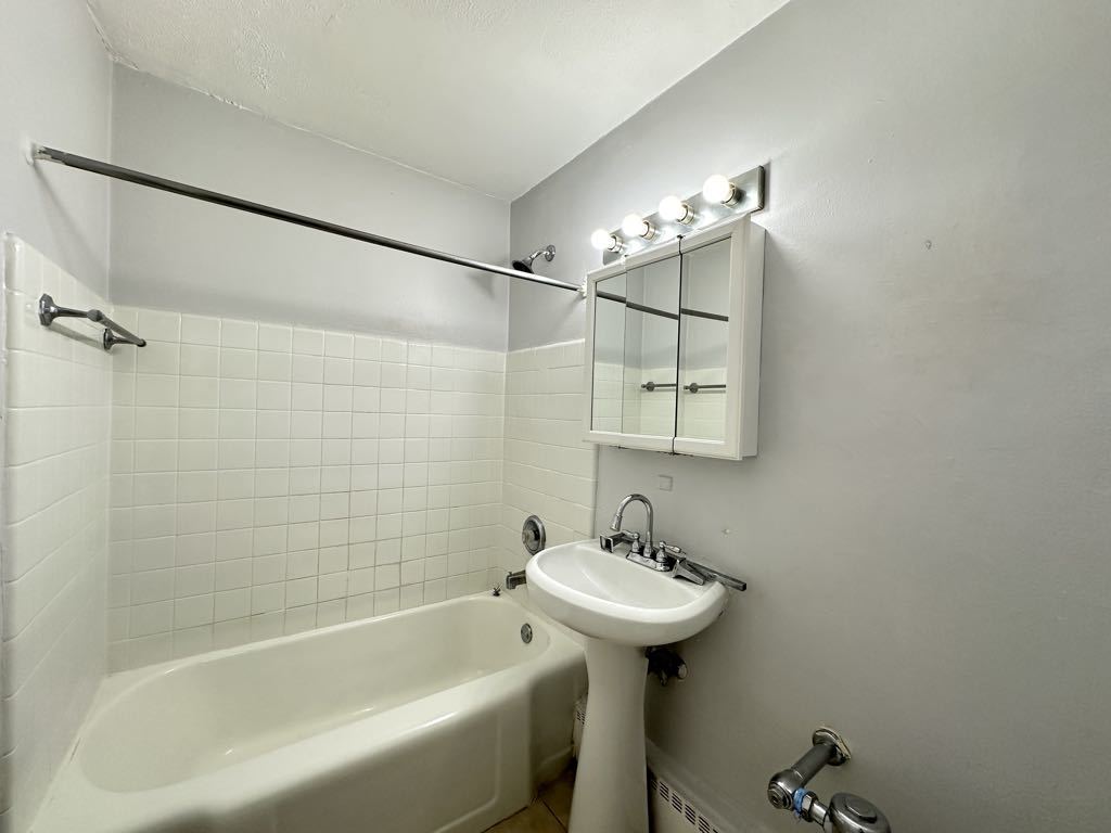 7333 North Ridge Boulevard, Unit 510 Chicago, IL 60645 - Photo 19 of 21 a bathroom with a sink a mirror and a bathtub
