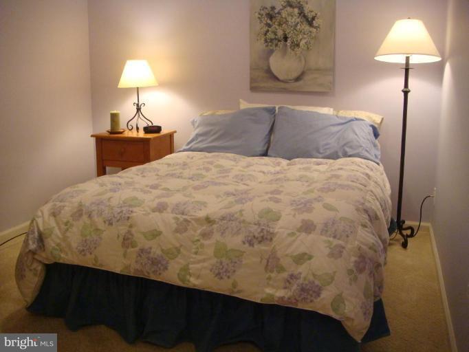 11467 Heritage Commons Way Reston, VA 20194 - Photo 13 of 19 a bedroom with a bed and a lamp