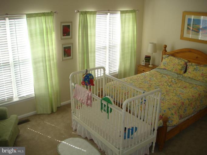 11467 Heritage Commons Way Reston, VA 20194 - Photo 3 of 19 a bedroom with a bed and windows