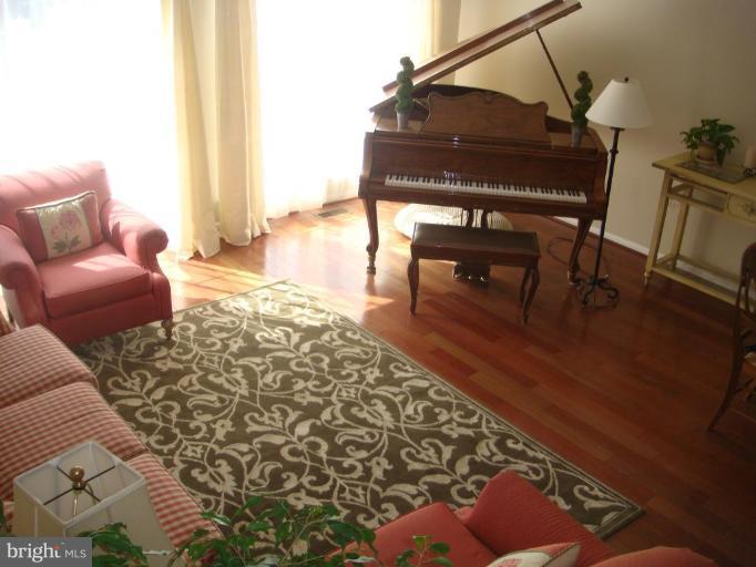 11467 Heritage Commons Way Reston, VA 20194 - Photo 10 of 19 a living room with furniture a dining table a lamp and a window