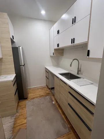 a kitchen with stainless steel appliances a sink a stove a refrigerator and cabinets