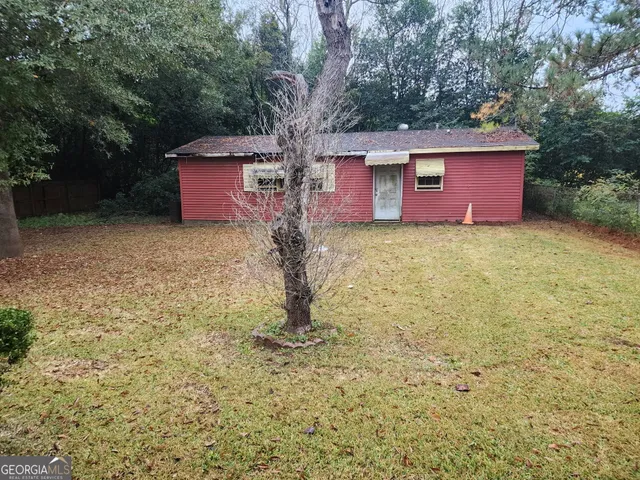 a large tree in front of a yard